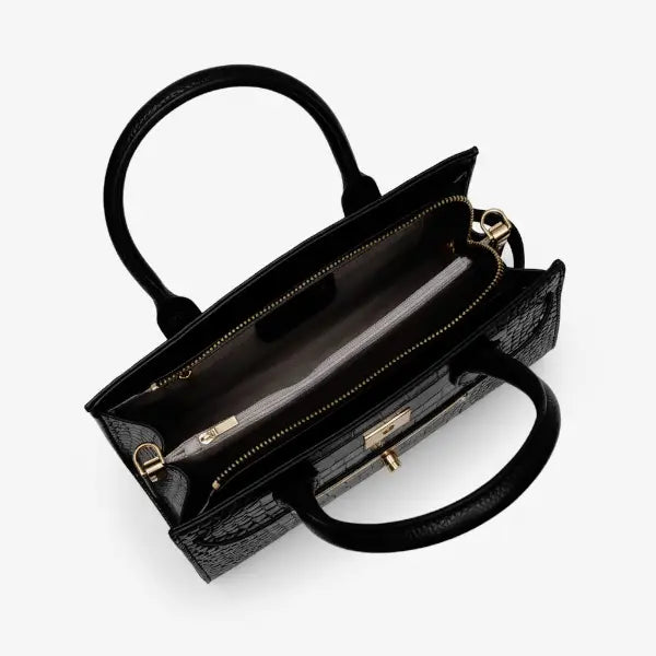 Interior of Adara black leather satchel bag with light fabric lining and gold zipper compartment