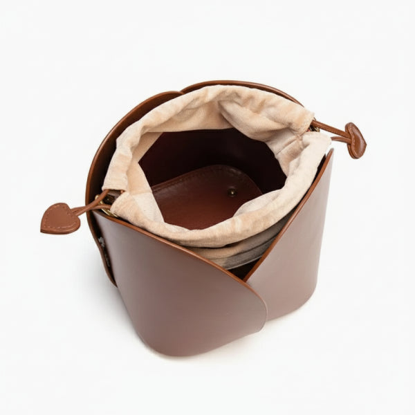 Althea Vegan Leather Bucket Bag in brown, top view of interior with beige drawstring pouch and heart-shaped pull tabs