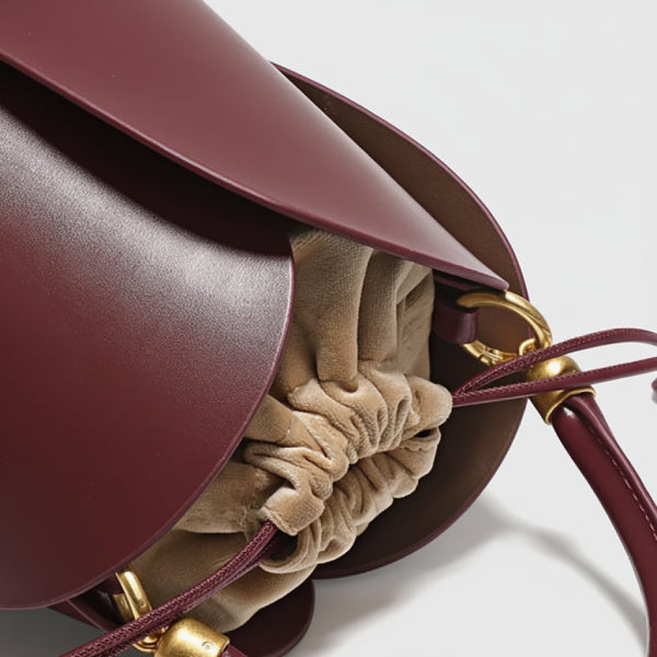 Althea Vegan Leather Bucket Bag in wine red, interior detail showing soft drawstring pouch, structured sides, and gold ring attachments