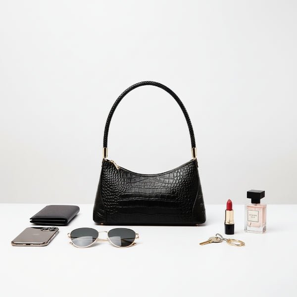 Black genuine cowhide leather shoulder bag displayed with complementary accessories, including sunglasses, lipstick, and a wallet, perfect for a fashionable lifestyle