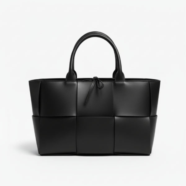 Front view of Aurelia black genuine leather tote bag with woven texture and leather handles, featuring a minimalistic design