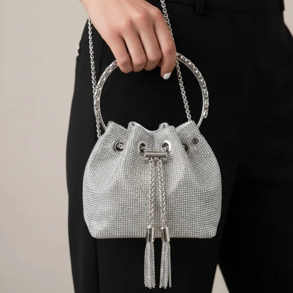 Aveline Rhinestone Crystal Evening Bag in silver, lifestyle shot with model hand-carrying by chain handle to show evening size and shine