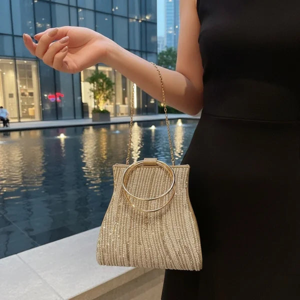 Celestia Rhinestone Crystal Evening Bag in gold, evening lifestyle by the water highlighting glittering crystals and ring handle