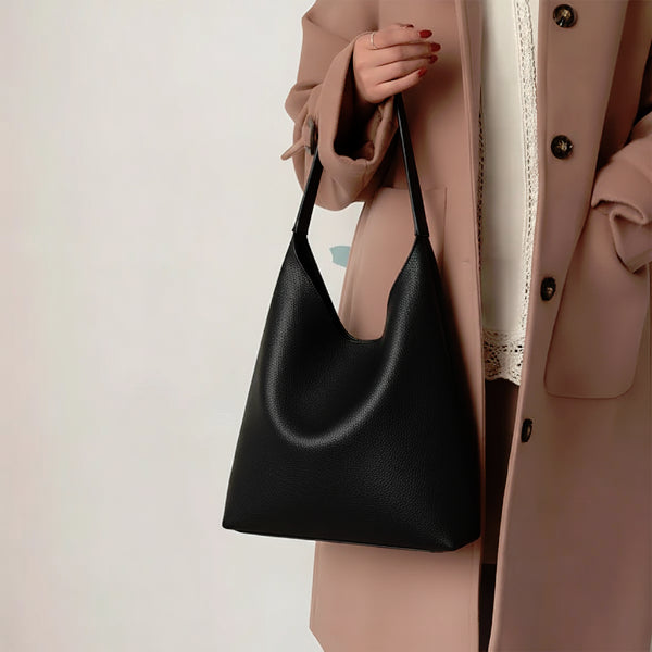 Model holding Elaria vegan leather hobo bag in black with spacious body and adjustable strap