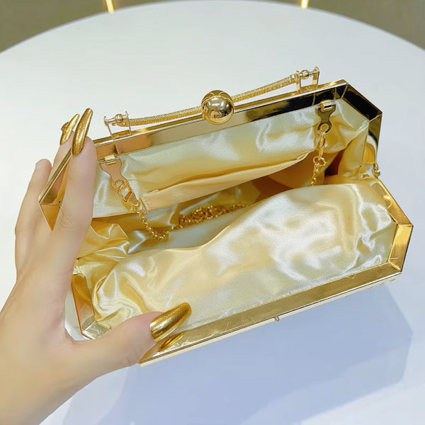 Interior view of a gold vegan leather evening bag with satin lining and a chain strap for easy carrying
