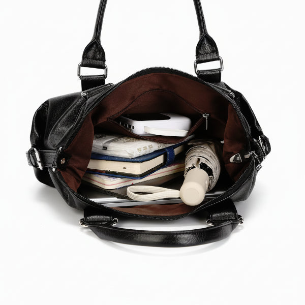 Interior of Mirelith black leather satchel bag showing spacious compartments with a dark fabric lining and organized pockets