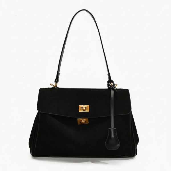 Front view of black velvet satchel bag featuring two gold clasps and a structured design