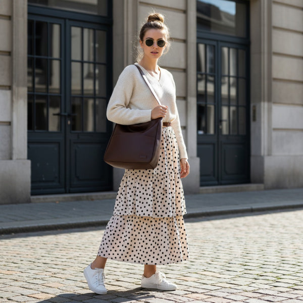 Model wearing Seliora vegan leather shoulder bag in coffee color while walking outdoors in casual outfit