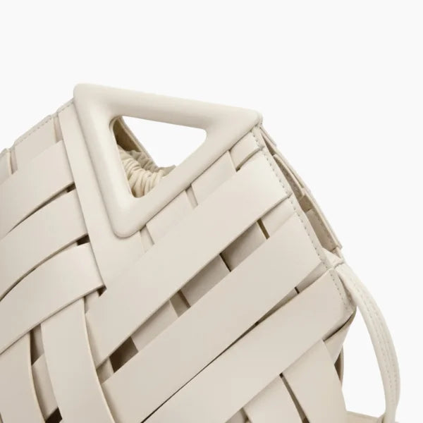 Seren Vegan Leather Bucket Bag in white, closeup highlighting triangular top handle and wide woven straps