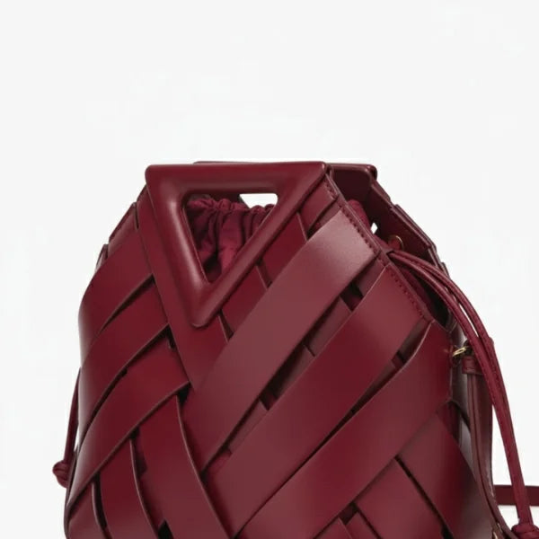 Seren Vegan Leather Bucket Bag in wine red, closeup highlighting triangular top handle, wide woven straps, and drawstring opening