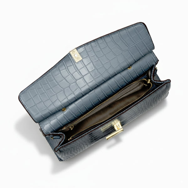 Inside view of blue crocodile leather satchel bag showing a spacious compartment and zipper pocket with gold accents