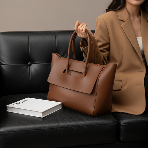 Model carrying a brown vegan leather tote bag, styled with a beige blazer for a sophisticated and elegant look