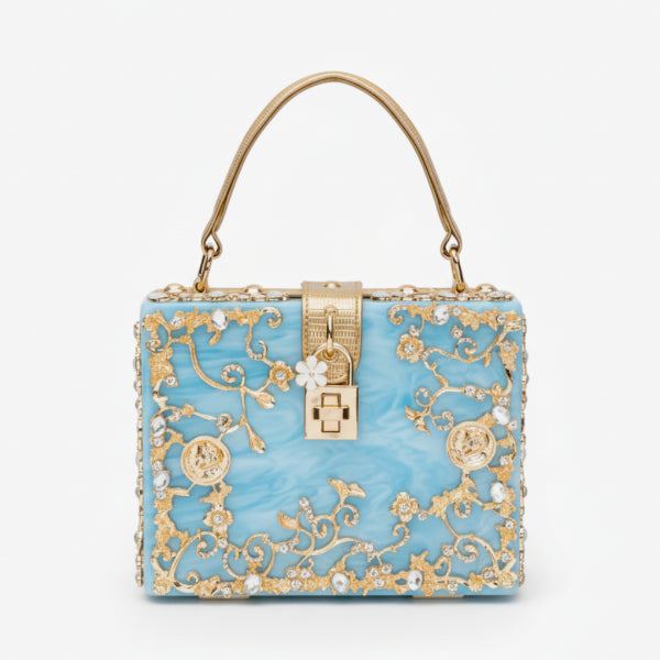 Front view of Zephyra acrylic evening bag in blue with intricate gold floral design and lock clasp