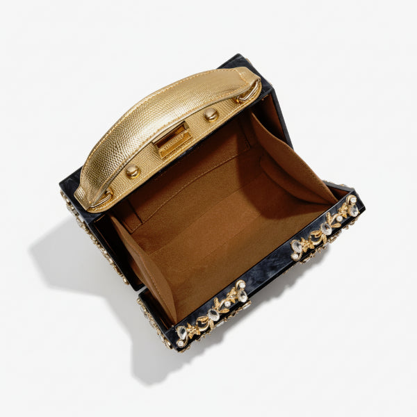 Interior view of Zephyra acrylic evening bag in black with gold accents and soft lining