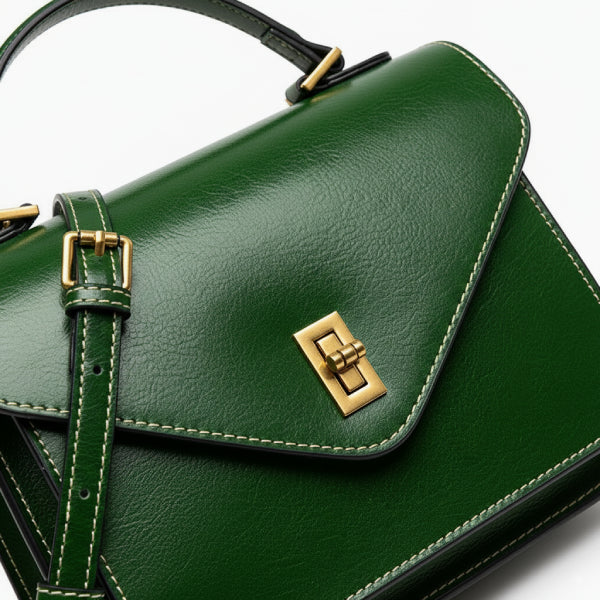 Close-up of the gold-tone clasp on the green genuine leather satchel bag, showcasing the sleek, luxurious design and fine craftsmanship