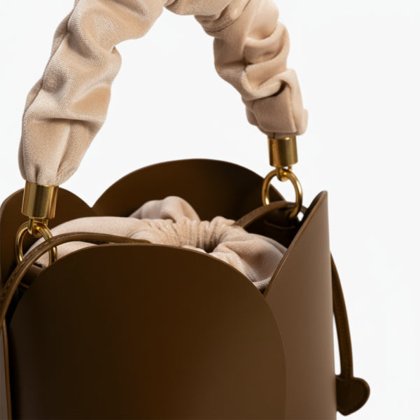 Althea Vegan Leather Bucket Bag in brown, closeup of ruched fabric top handle with gold hardware and drawstring closure