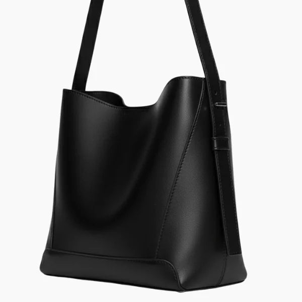 Amara Vegan Leather Bucket Bag in black, side closeup showing smooth vegan leather, structured base, and adjustable shoulder strap
