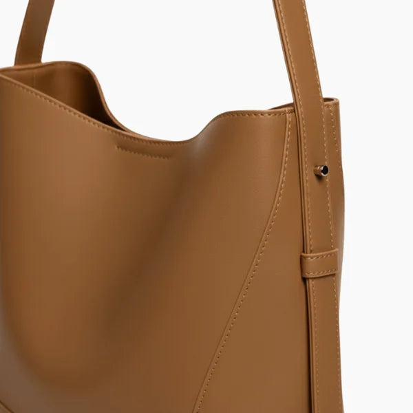 Amara Vegan Leather Bucket Bag in brown, side closeup highlighting smooth vegan leather, clean stitching, and adjustable shoulder strap
