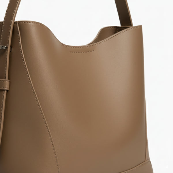 Amara Vegan Leather Bucket Bag in caramel, side closeup showing smooth vegan leather, neat stitching, and adjustable strap
