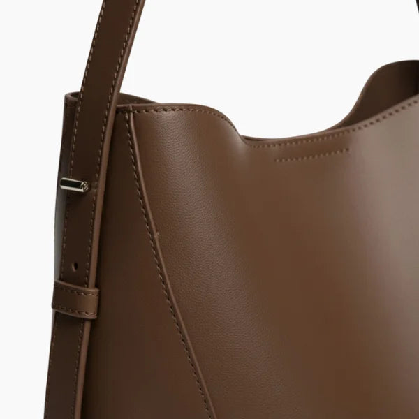 Amara Vegan Leather Bucket Bag in coffee brown, side closeup showing smooth vegan leather, clean stitching, and adjustable strap