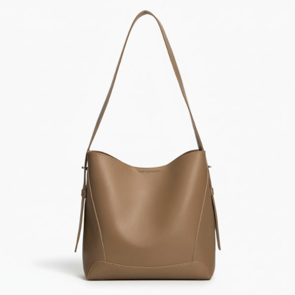 Amara Vegan Leather Bucket Bag in caramel, front studio view highlighting clean bucket silhouette and wide shoulder strap