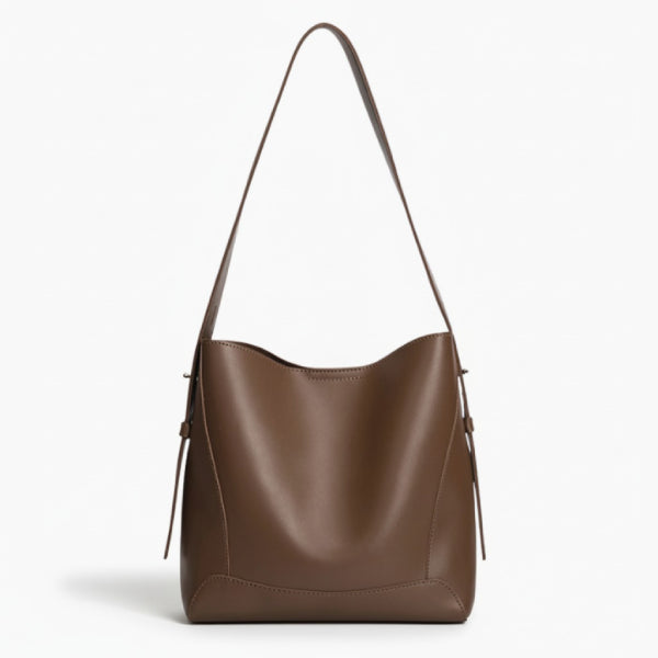 Amara Vegan Leather Bucket Bag in coffee brown, front studio view highlighting minimalist bucket silhouette and wide shoulder strap