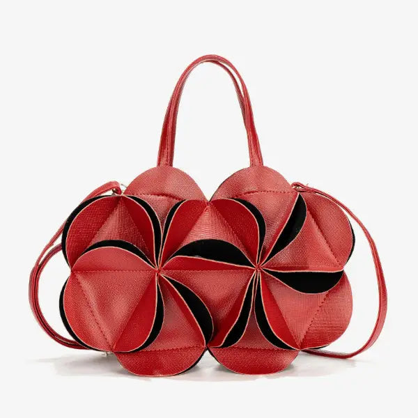 Front view of a red vegan leather evening bag with a flower-shaped design, contrasting black accents, and elegant top handles