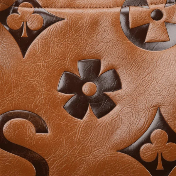 Closeup of Amora embossed vegan leather tote bag in brown with floral and geometric embossed design
