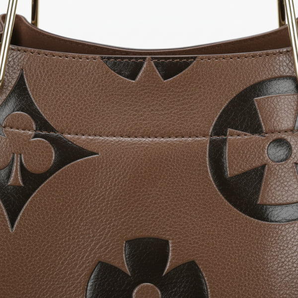 Closeup of Amora embossed vegan leather tote bag in coffee color showing detailed embossed floral patterns