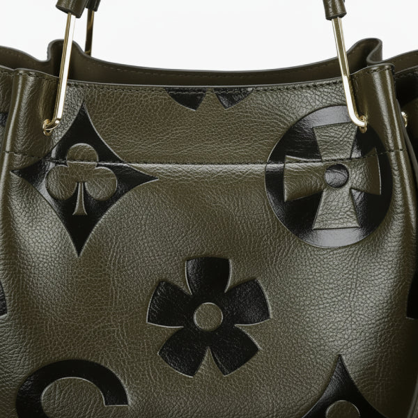 Closeup of Amora embossed vegan leather tote bag in green with floral and geometric embossed patterns