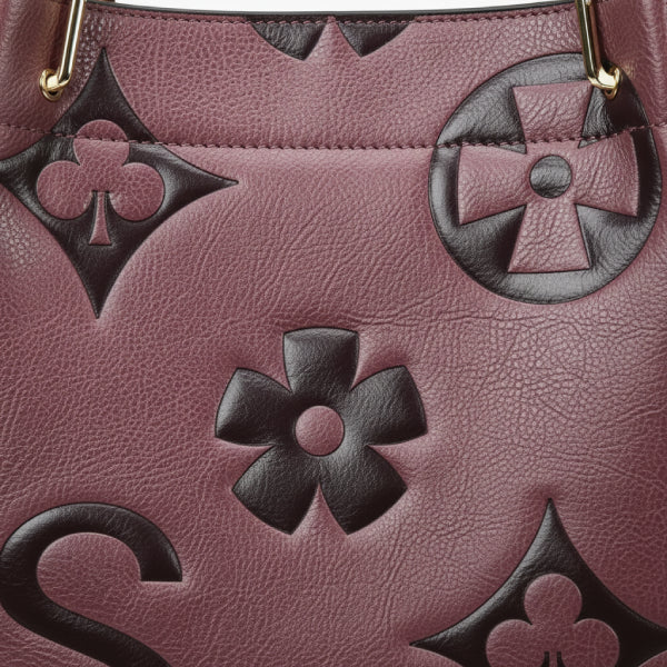 Closeup of Amora embossed vegan leather tote bag in purple showing detailed embossed floral patterns