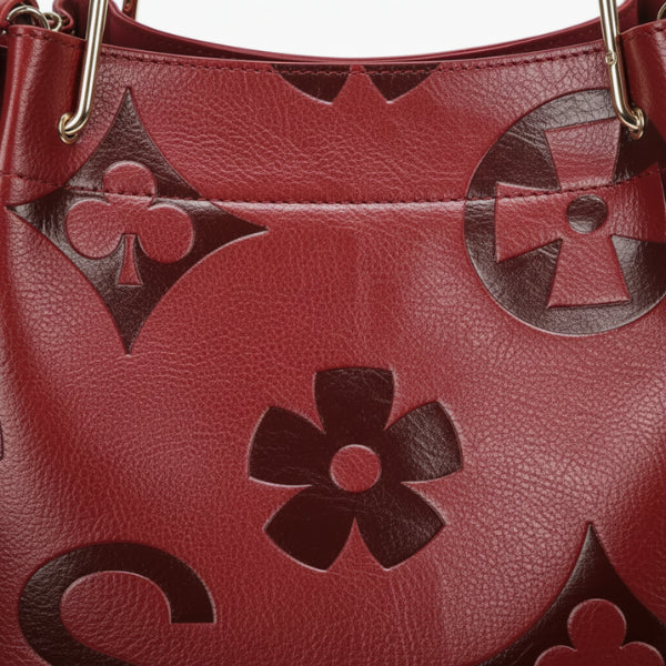 Closeup of Amora embossed vegan leather tote bag in wine red with floral and geometric embossed patterns