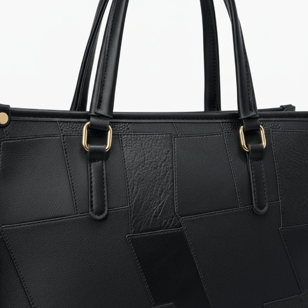 Close-up of the Anelisse vegan leather tote bag in black highlighting the textured leather and gold-tone hardware