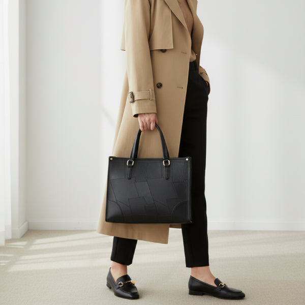Anelisse vegan leather tote bag in black worn by model with a chic, professional design and contrasting gold accents
