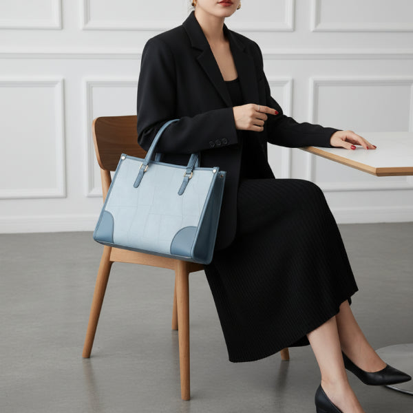 Anelisse vegan leather tote bag in blue worn by model, showcasing its sophisticated design with contrasting gold hardware