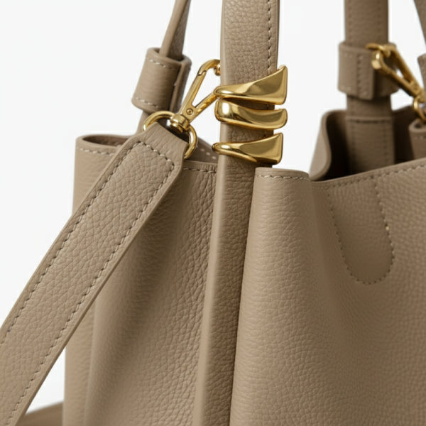 Arden Genuine Leather Bucket Bag in beige, closeup of pebbled leather and gold hardware with detachable crossbody strap