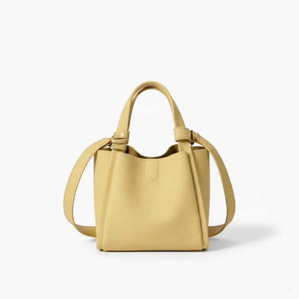 Arden Genuine Leather Bucket Bag in off-yellow, front studio view showcasing compact bucket shape, top handles, and crossbody strap