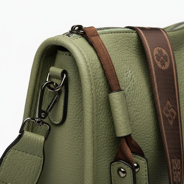Auralis Genuine Cowhide Crossbody Bag in green, closeup highlighting pebbled leather, silver hardware, and wide brown jacquard strap