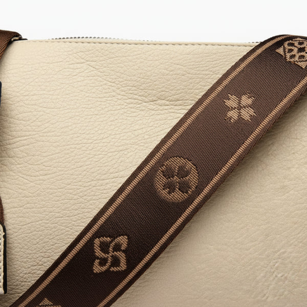 Auralis Genuine Cowhide Crossbody Bag in off-white, closeup highlighting pebbled leather texture and brown jacquard shoulder strap