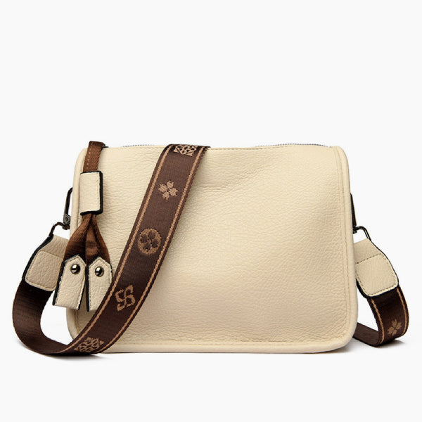 Auralis Genuine Cowhide Crossbody Bag in off-white, front studio view showcasing rectangular silhouette, zip-top closure, and adjustable patterned strap