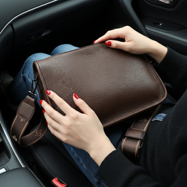 Auralis Genuine Cowhide Crossbody Bag in brown, lifestyle shot on model showing compact rectangular shape and wide patterned shoulder strap