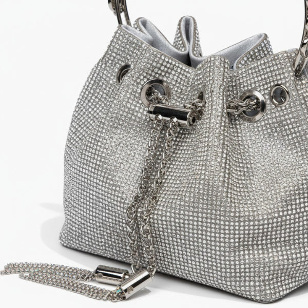 Aveline Rhinestone Crystal Evening Bag in silver, closeup showcasing allover crystals, metal eyelets, chain drawstring and tassel detail