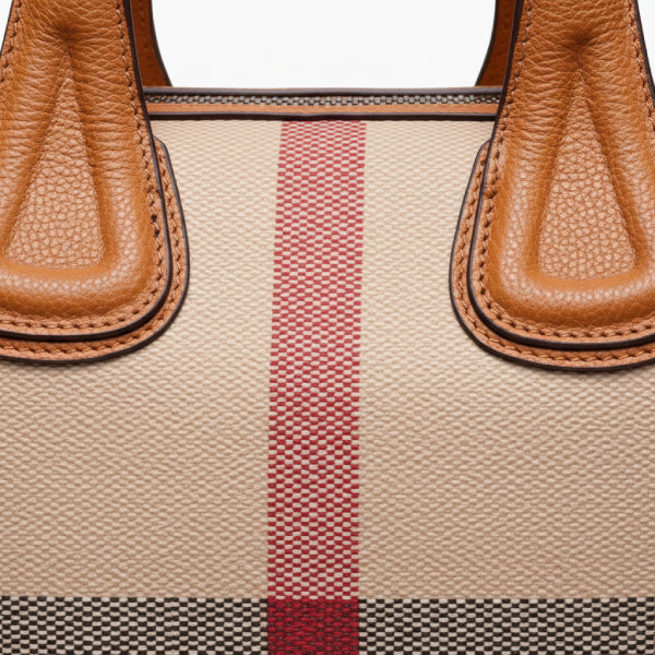 Detailed view of the textured brown vegan leather on the tote bag, highlighting the sleek stitching and durable material