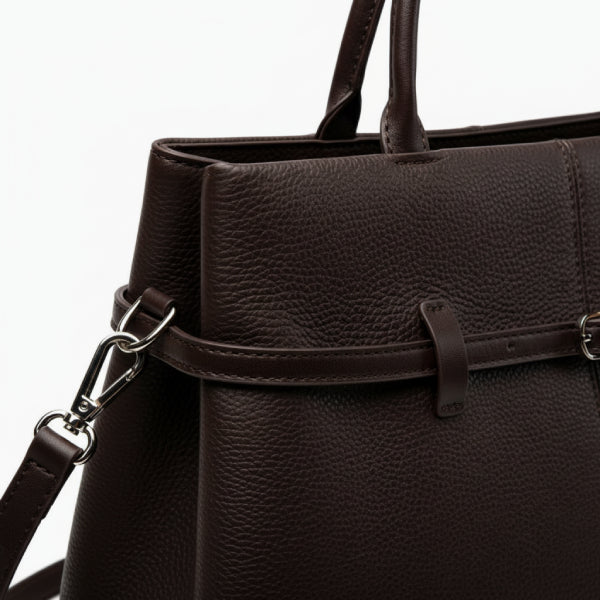 Close-up of a brown coffee-colored genuine leather tote bag showcasing high-quality stitching and a stylish buckle detail