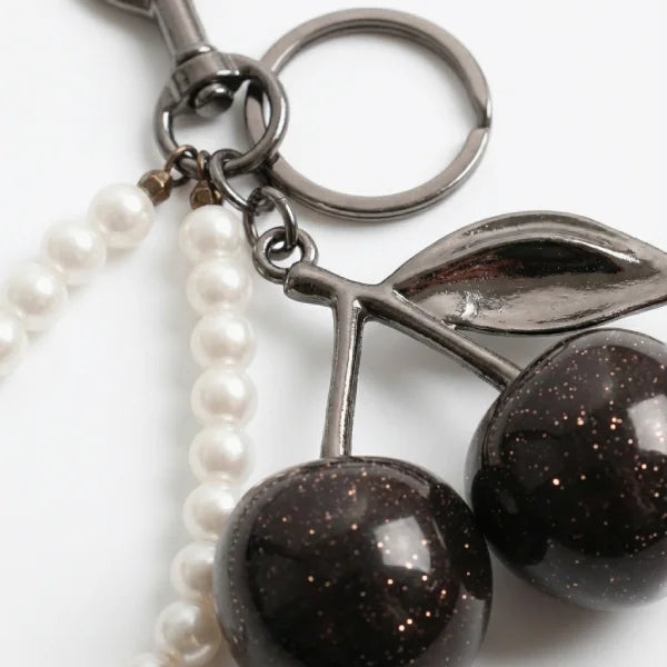 Keychain with cherry and pearl design on a white background