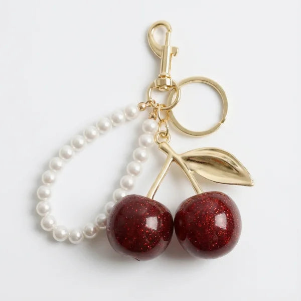 Keychain with cherries and pearls on a white background