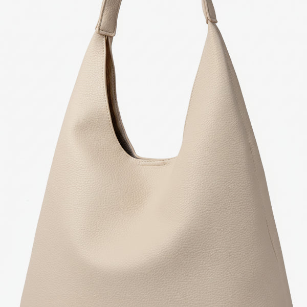 Close-up of Elaria vegan leather hobo bag in off-white, showing the textured surface and smooth handle