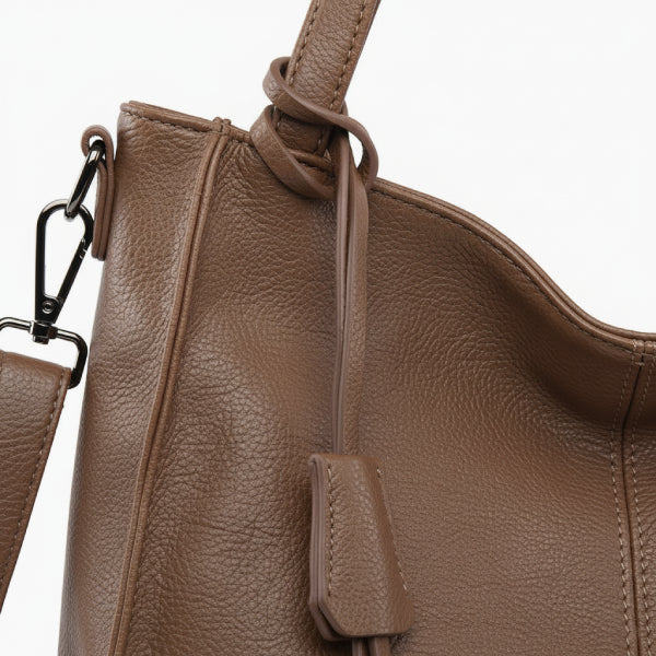 Close-up of the brown vegan leather tote bag with smooth texture and a stylish leather tassel hanging from the strap