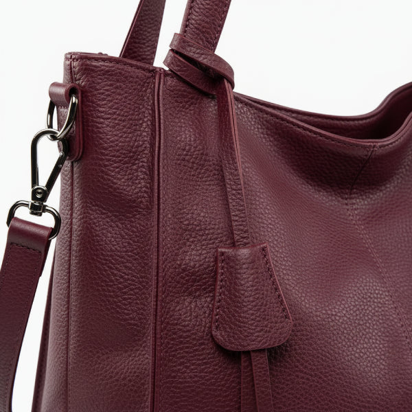 Close-up of the wine red vegan leather tote bag, highlighting its smooth texture, high-quality stitching, and decorative leather tassel