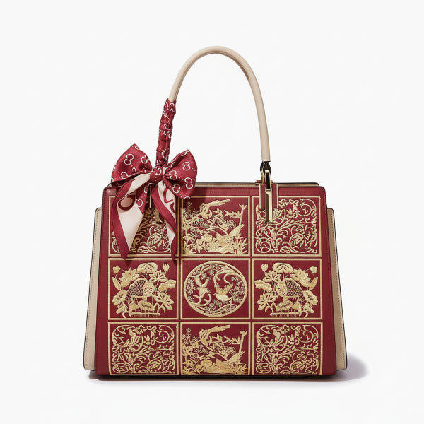 Front view of the off-red Elisandra embroidered tote bag with a beautiful floral embroidery design, highlighted by a red bow on the handle